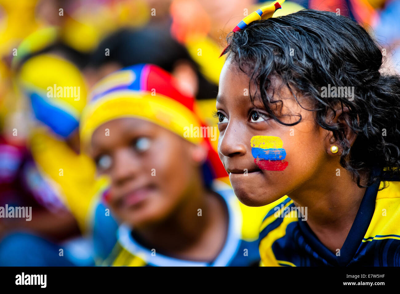 Ein kolumbianischer Mädchen Uhren das Fußballspiel, bei der FIFA Fußball-Weltmeisterschaft 2014, in einem Park in Cali, Kolumbien. Stockfoto