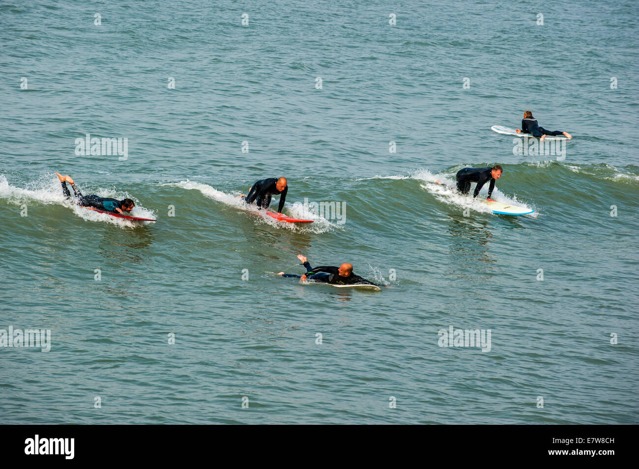 Mittleren Alters Surfer in Neoprenanzüge auf Welle auf Surfboards, wie es auf dem Meer bricht Stockfoto