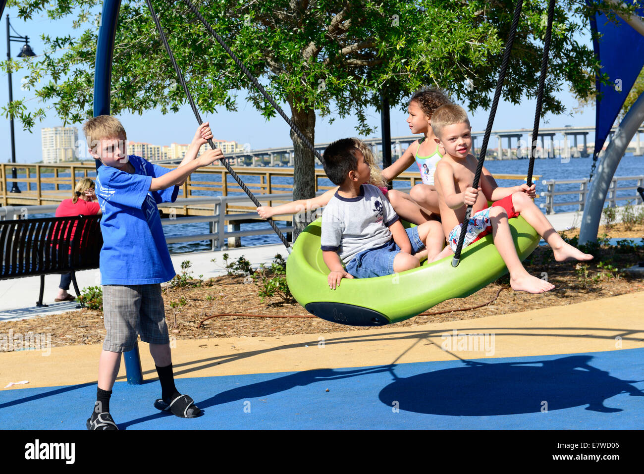 Kinder und Kleinkinder, die an einen modernen sicheren Spielplatz spielen Stockfoto