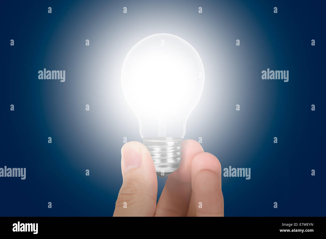 Hand, die leuchtende Glühbirne mit blauem Hintergrund. Stockfoto