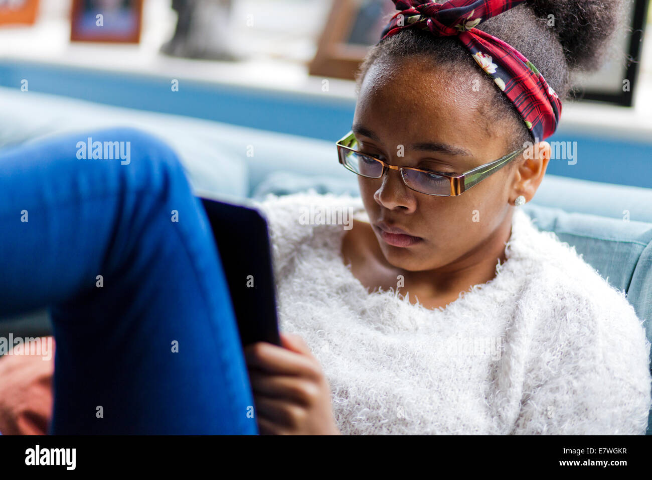 Gemischte Rasse Teenager-Mädchen Lesung auf einem Kindle Stockfoto