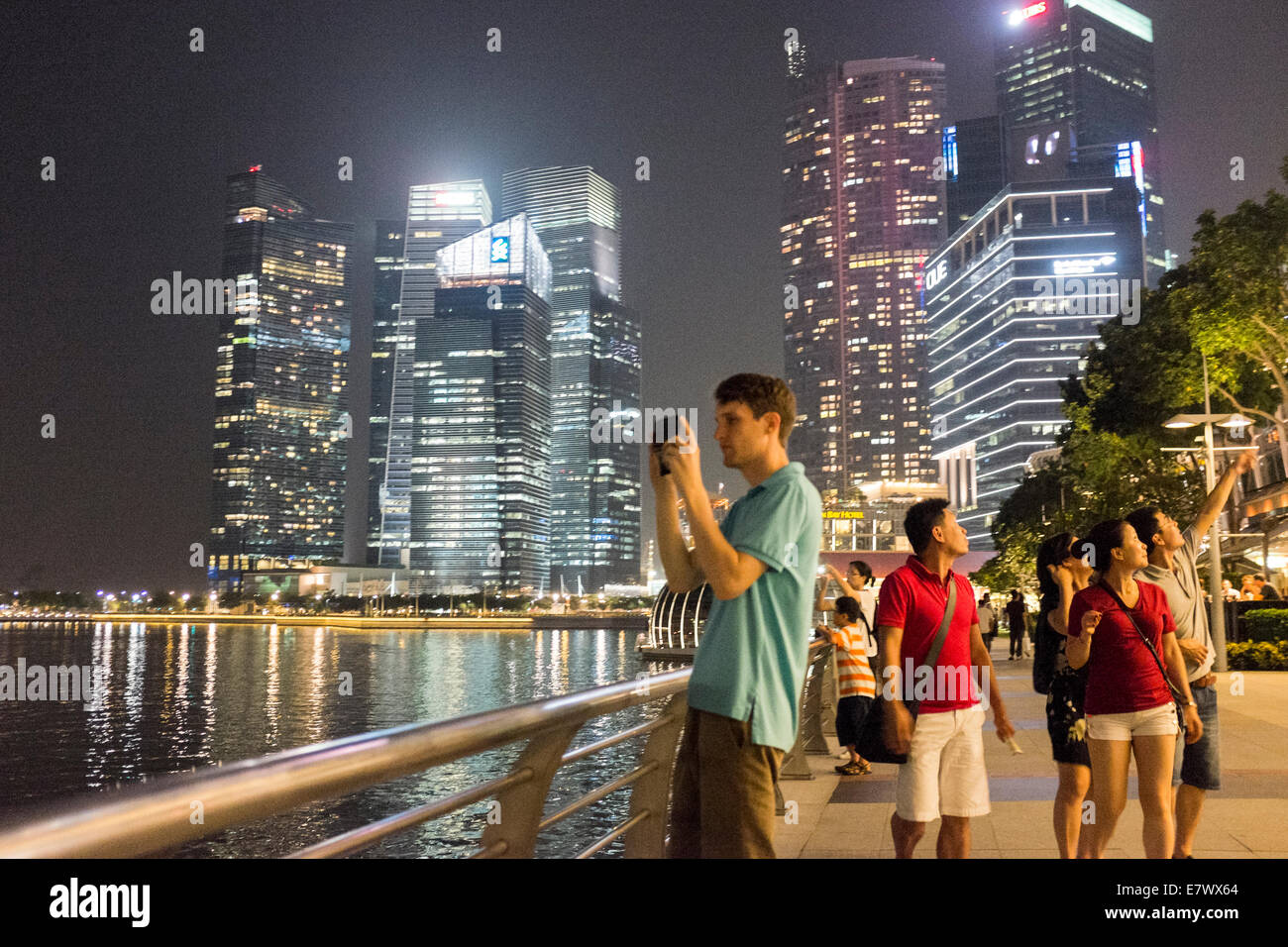 Ein Mann nimmt ein Bild von dem central Business District auf der Watefront in Singapur. Stockfoto