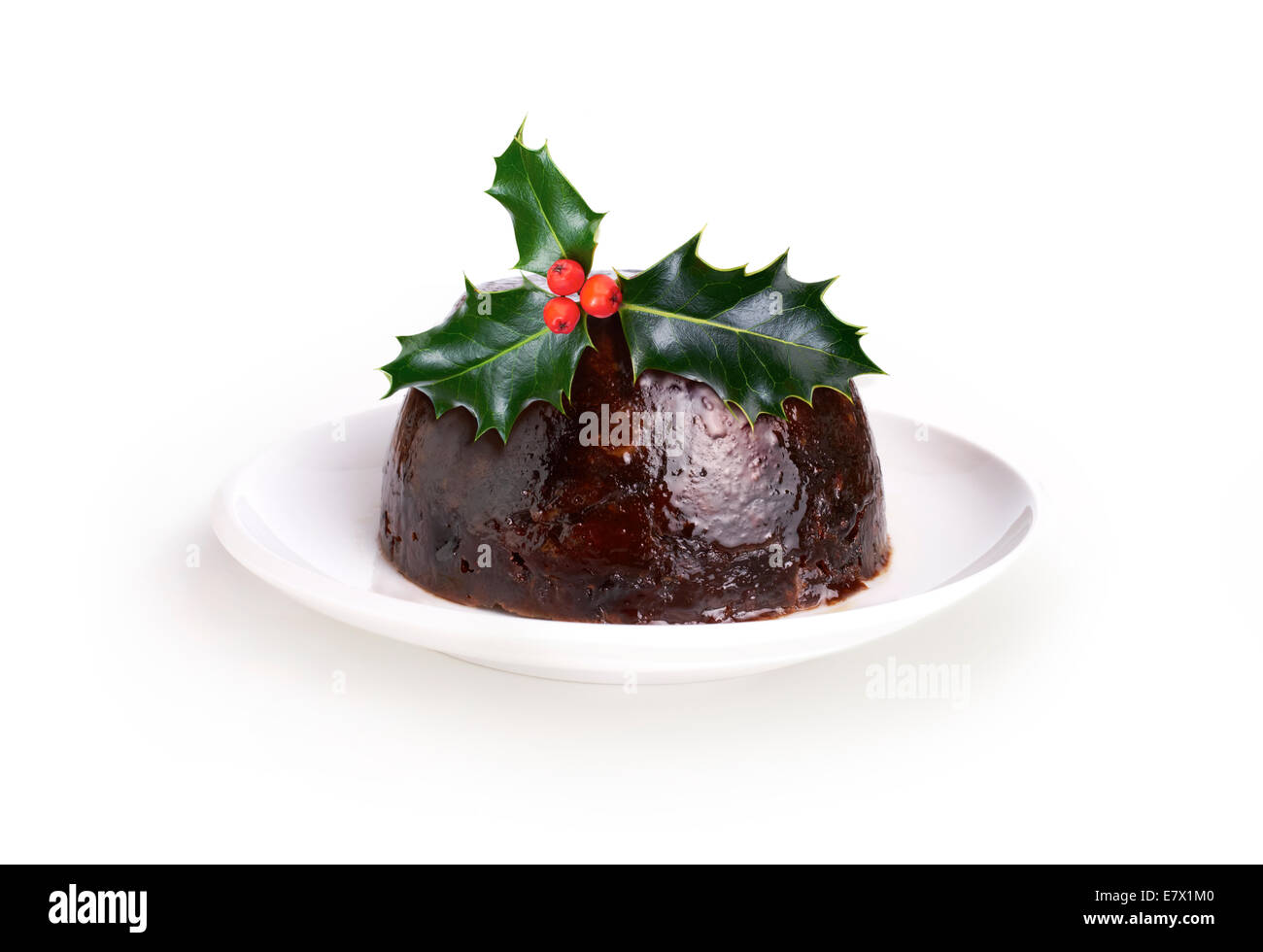 Christmas Pudding mit einem Zweig der Stechpalme isoliert auf weißem Hintergrund. Stockfoto