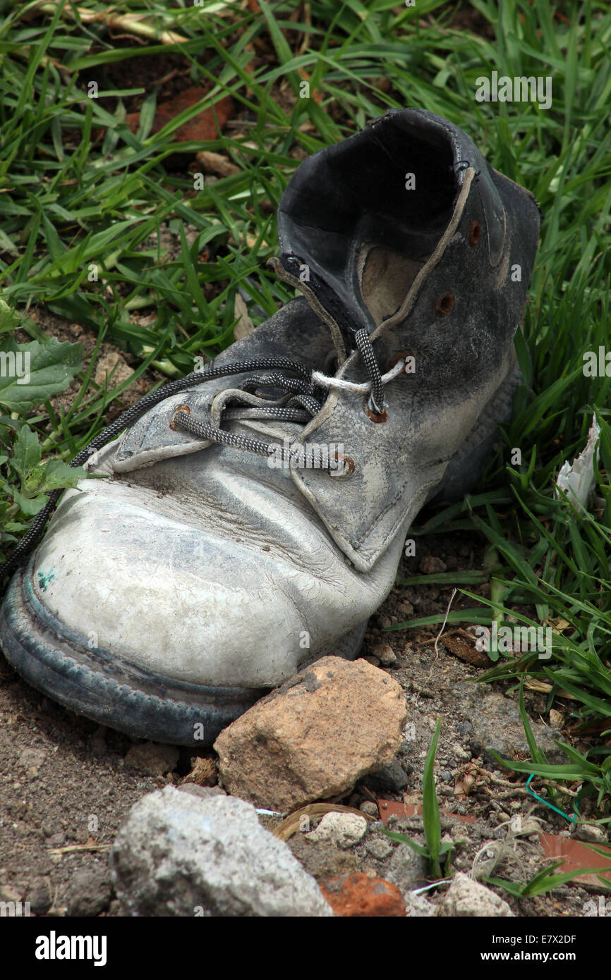 Ein altes verworfen Arbeitsstiefel neben einem Felsen in Cotacachi, Ecuador Stockfoto