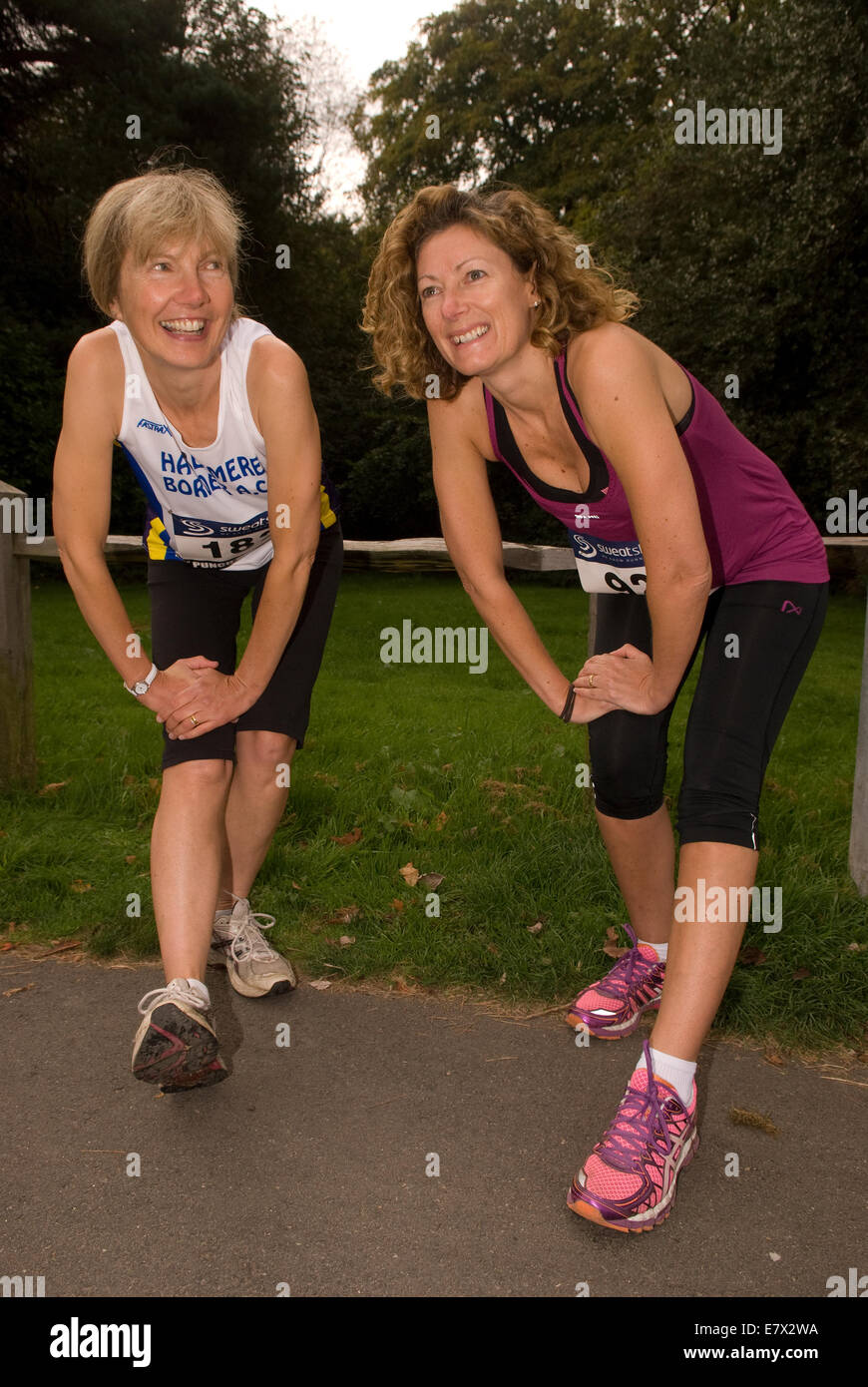 Zwei Frauen, die dehnungsübungen/Aufwärmen vor einer 10 km für Nächstenliebe, hindhead, Surrey, Großbritannien. Stockfoto
