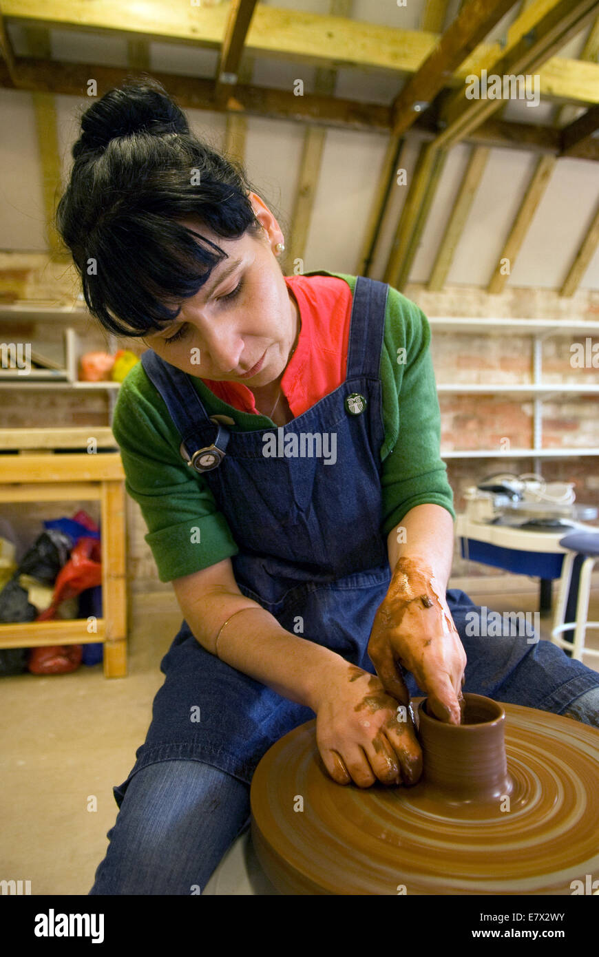 Frau demonstriert Tonnapf Herstellung auf dem Wurfrad an einem Erbe und Demonstrationstag bei einer lokalen Keramik, Farnham, Surrey, Großbritannien. Stockfoto