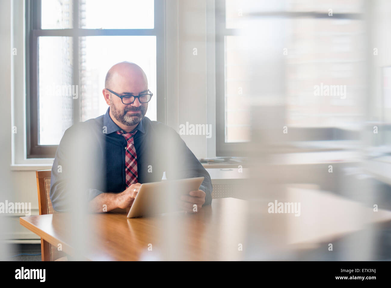 Ein Geschäftsmann sitzt an seinem Schreibtisch, die Arbeit am Computer. Stockfoto