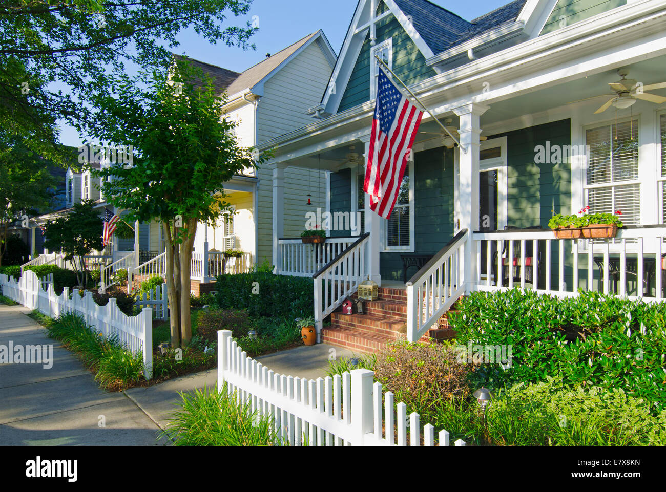 Der amerikanische Traum von einem Haus mit einer Fahne und einer weißen Lattenzaun im Vorgarten erwacht zum Leben in dieses ikonische Bild. Stockfoto