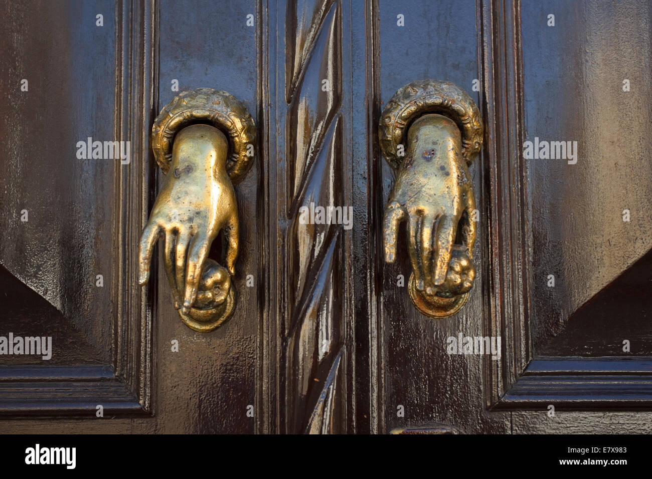 Braune Tür in der alten Stadt Tavira haben kleine Messing Türgriffe in der Form der Hände. Stockfoto