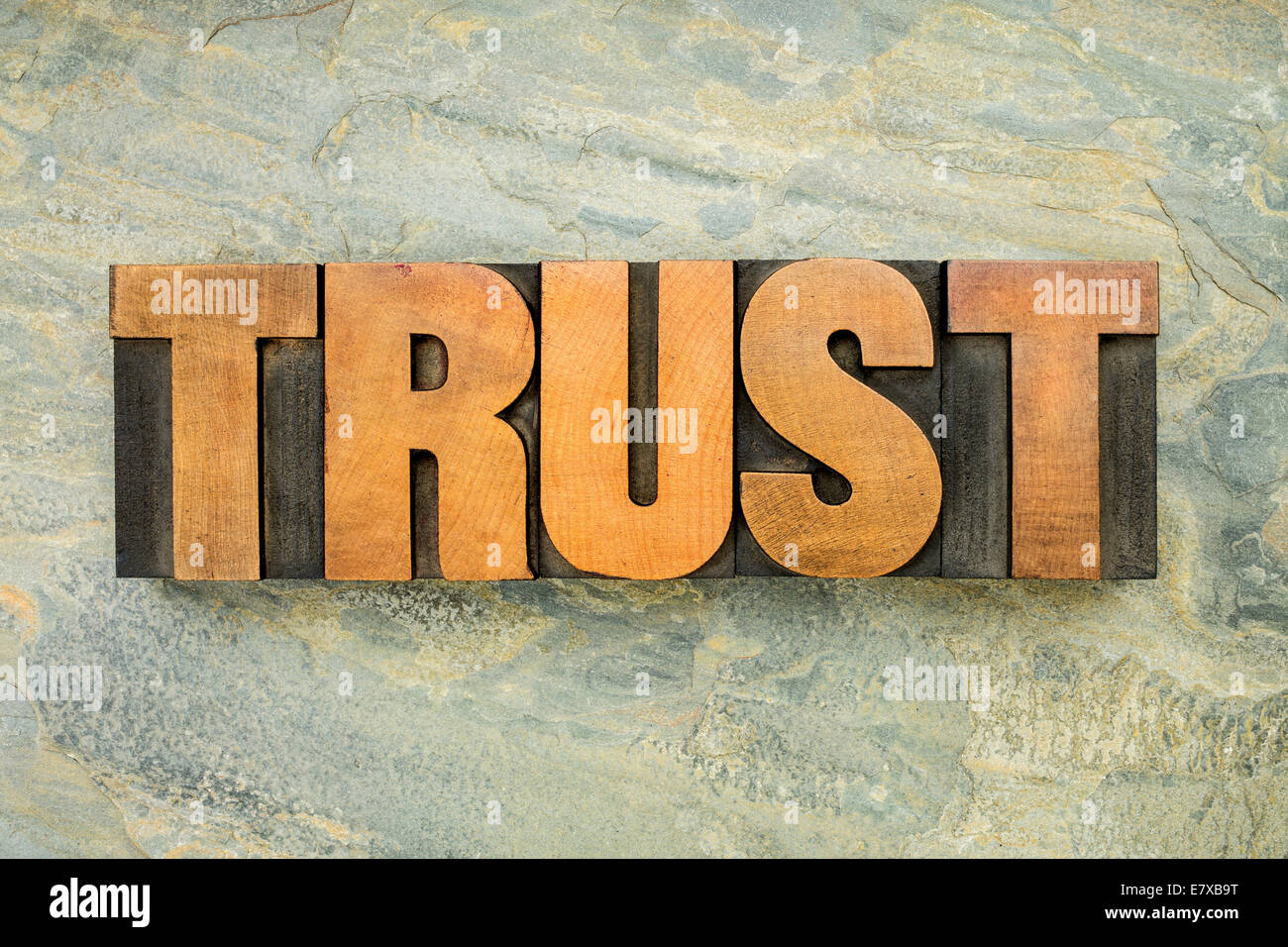 Vertrauen - ein Wort in Vintage Buchdruck Holzart auf grünem Schiefer Felsen Hintergrund Stockfoto