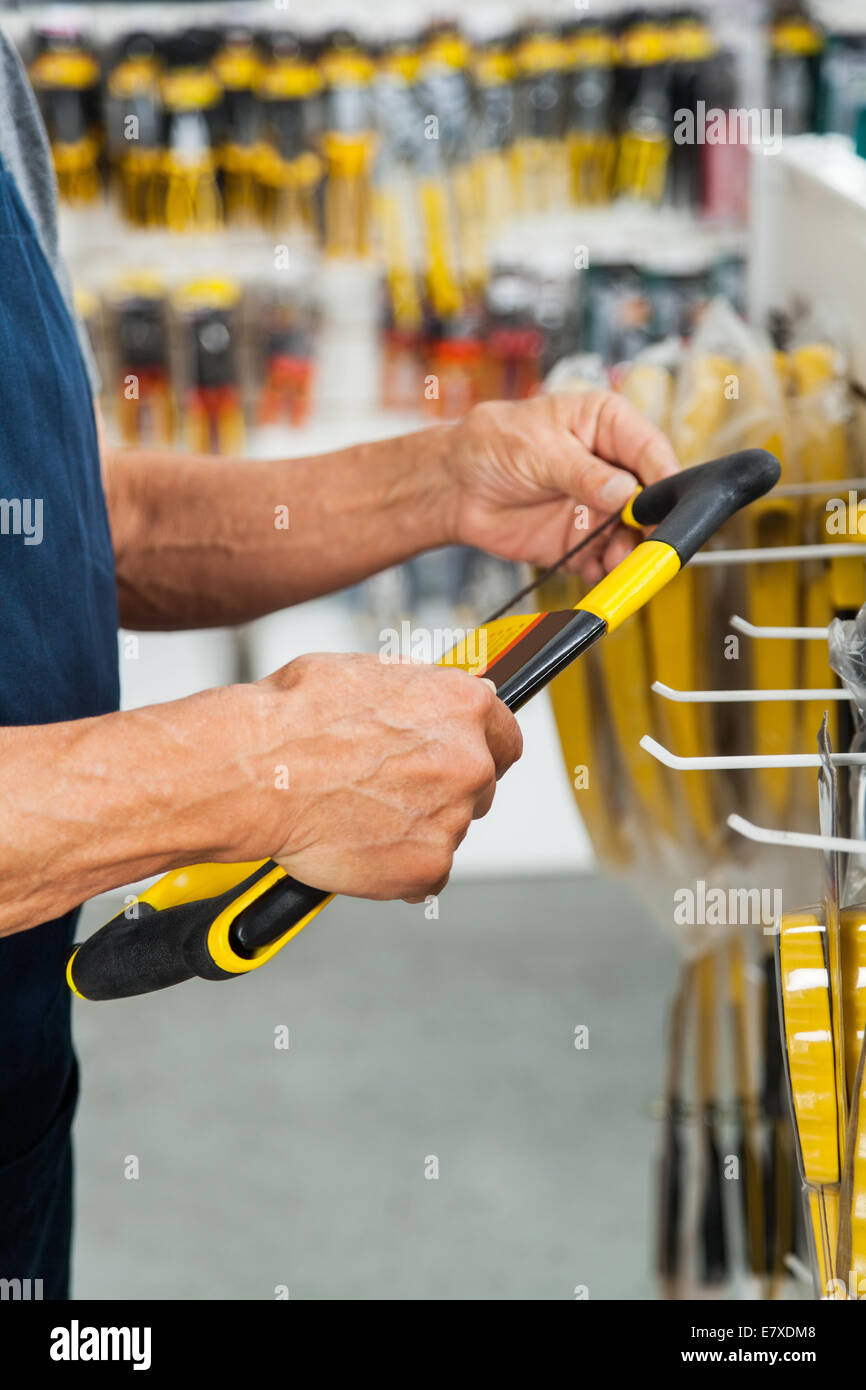 Verkäufer-Holding-Säge im Store Stockfoto