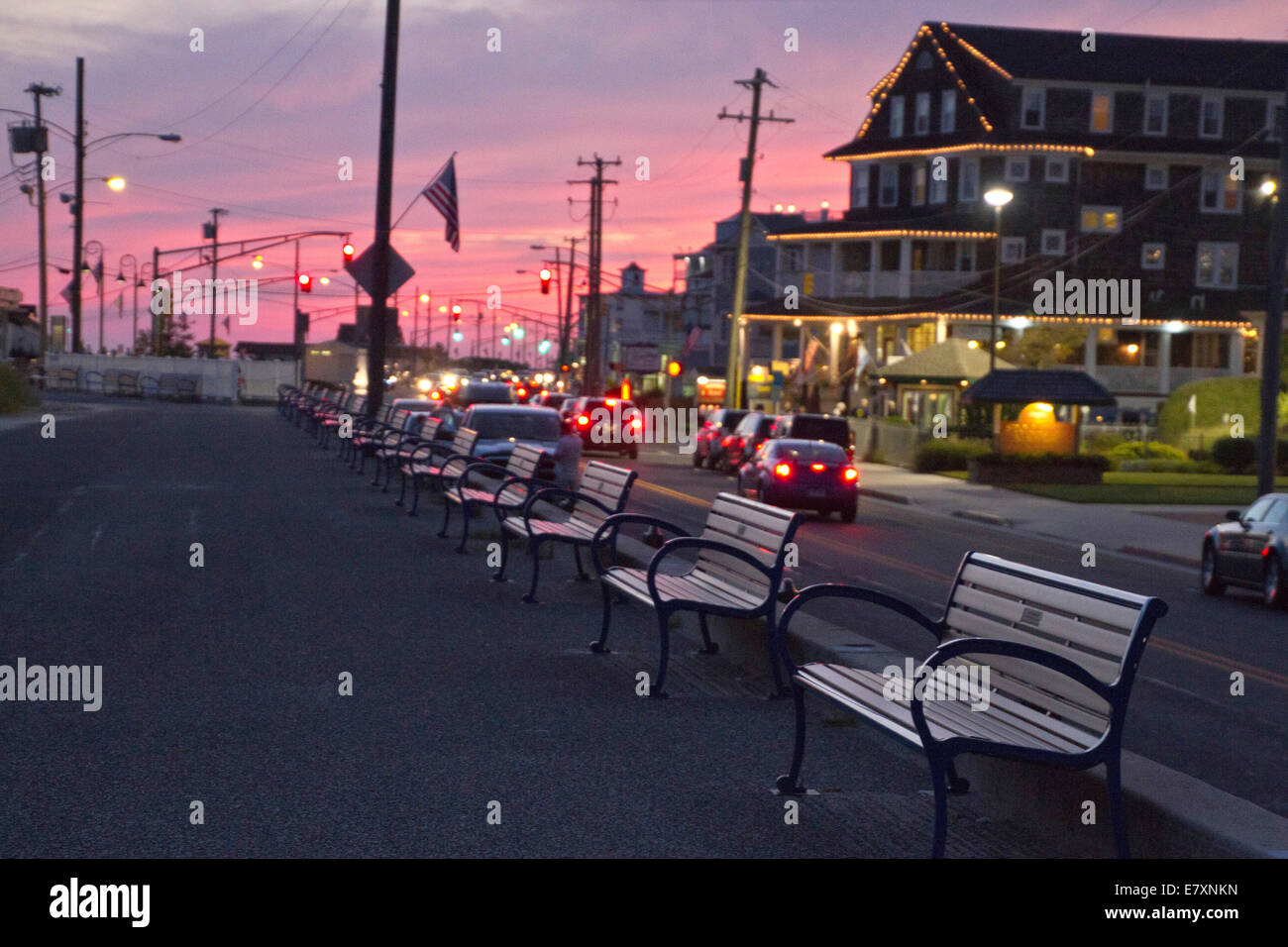 Blick auf den Bänken entlang der Zement Gehweg grenzt an den Strand in Cape May, New Jersey bei Sonnenuntergang Stockfoto