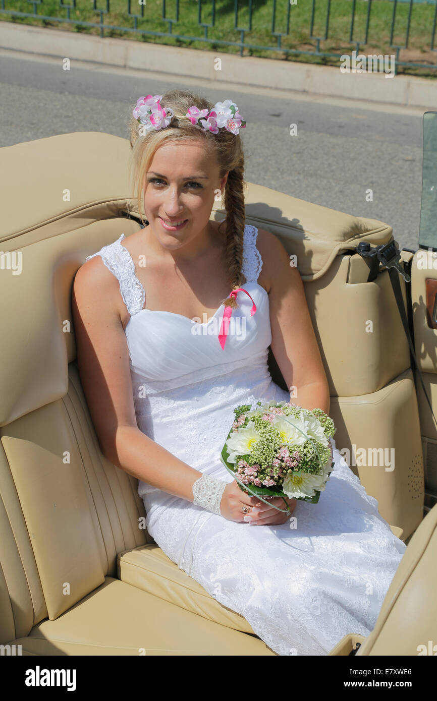 Braut posiert auf dem Rücksitz eines offenen Autos, Cabrio Stockfoto