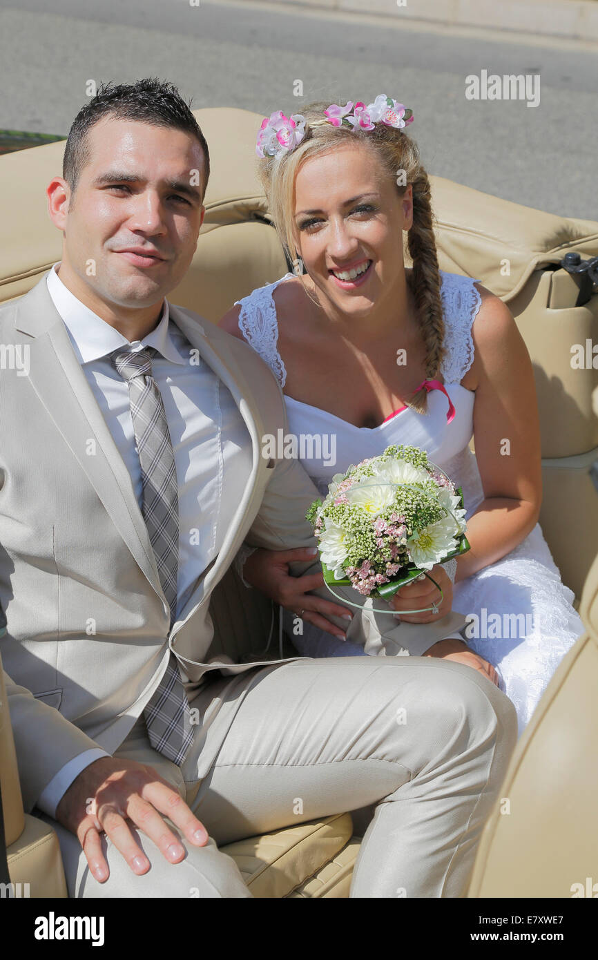 Braut und Bräutigam posiert auf dem Rücksitz eines offenen Autos, Cabrio Stockfoto
