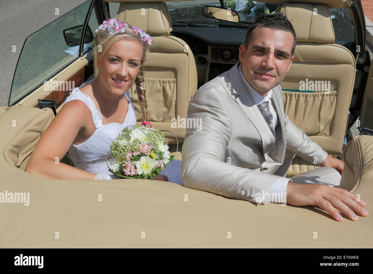 Braut und Bräutigam posiert auf dem Rücksitz eines offenen Autos, Cabrio Stockfoto