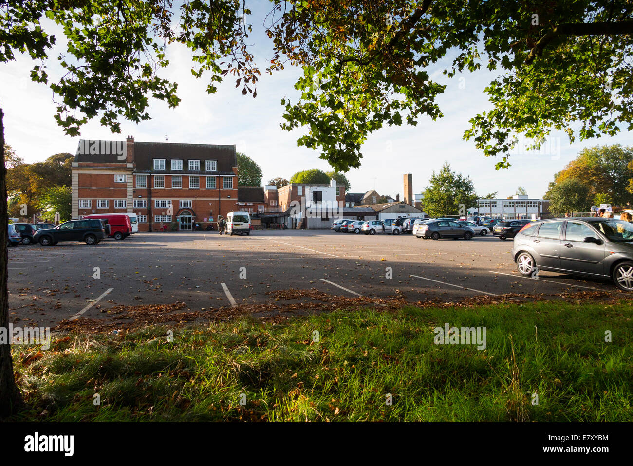 Schule-Parkplatz während der Vorlesungszeit / Autos parken am Morgen an einer primären und sekundären Schule absetzen. VEREINIGTES KÖNIGREICH. Stockfoto