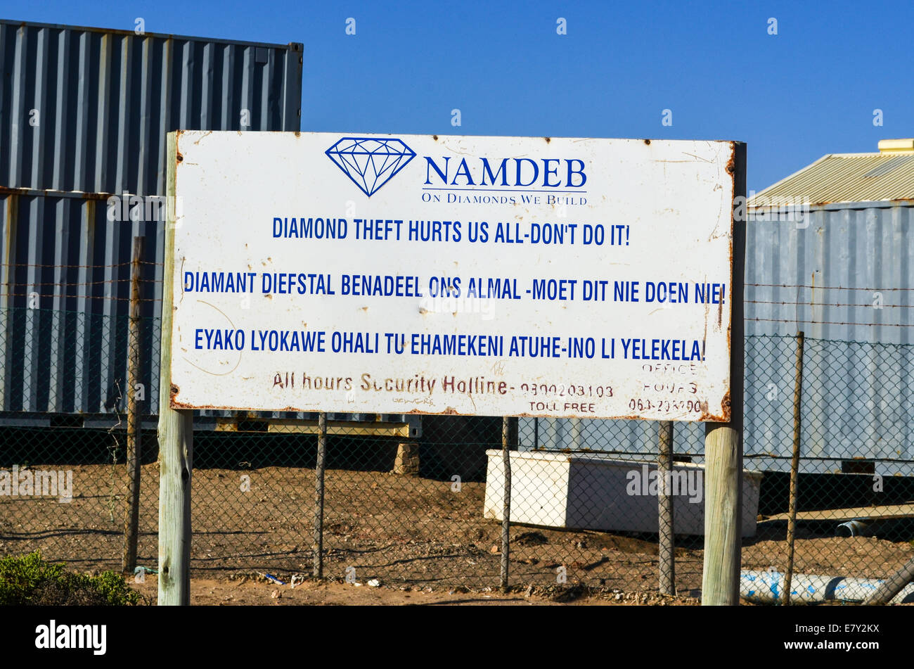 NAMDEB Diamant Bergbau Firma Warnschild gegen Diamond Diebstahl und Container im Hintergrund, Lüderitz, Namibia Stockfoto