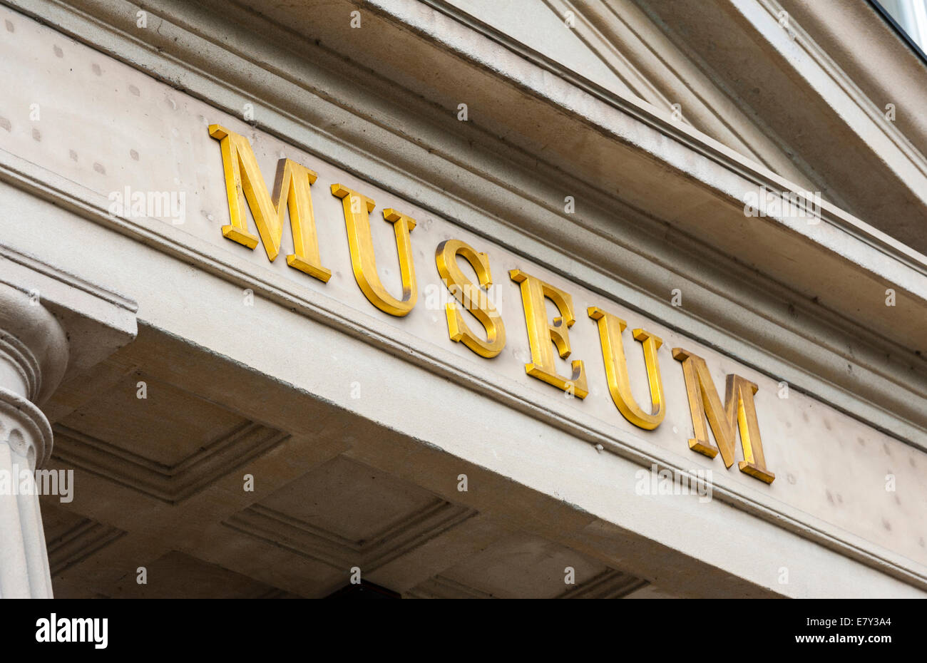 Eingangsportal zu einem Museum mit Capitol und griechischen Säulen. goldenen Buchstaben 'Museum' geschrieben am Kapitol. Stockfoto