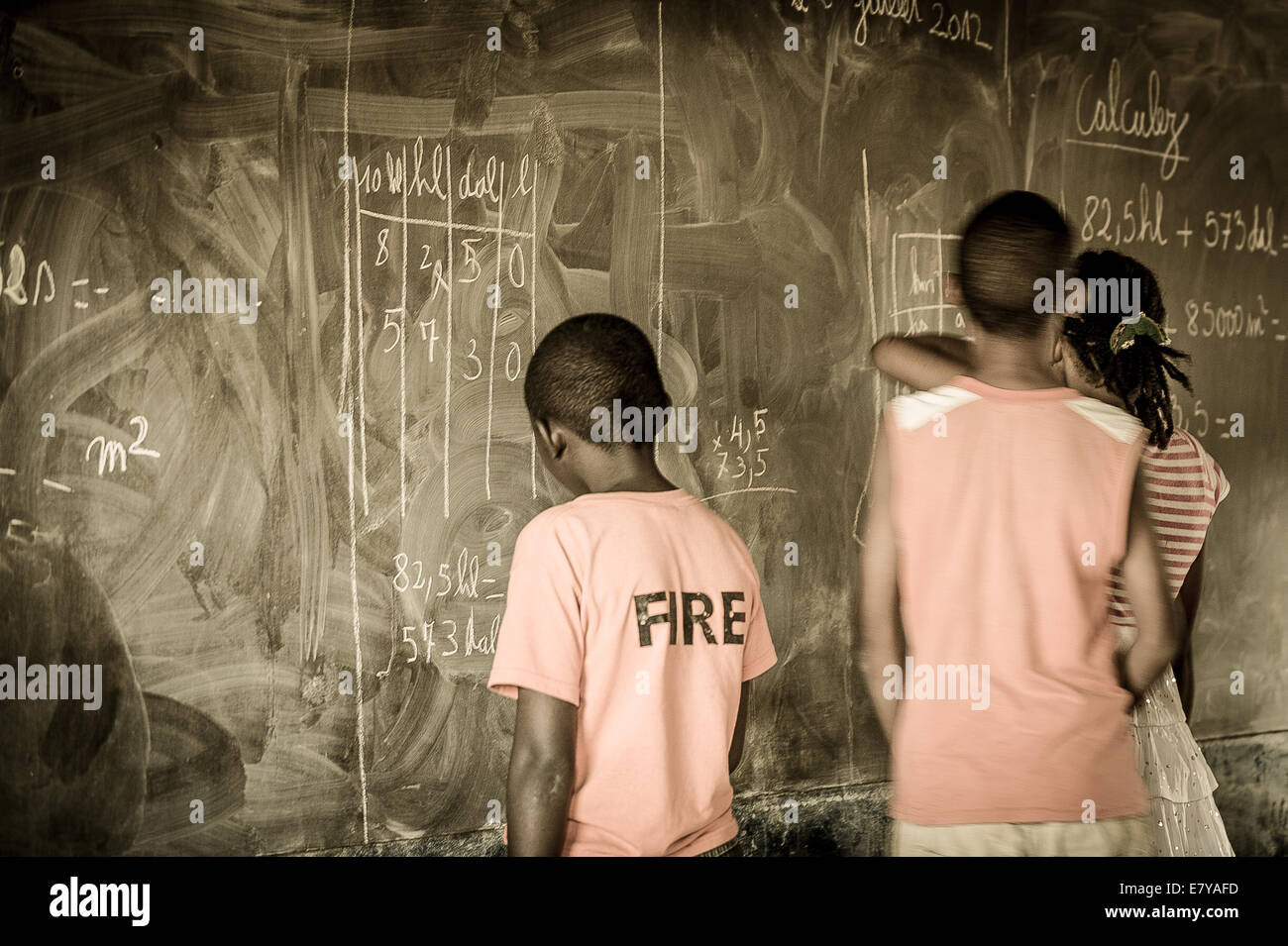 Drei junge Studenten schreiben auf einer Tafel im Klassenzimmer. Hell-Ville-Schule. Madagaskar. Stockfoto