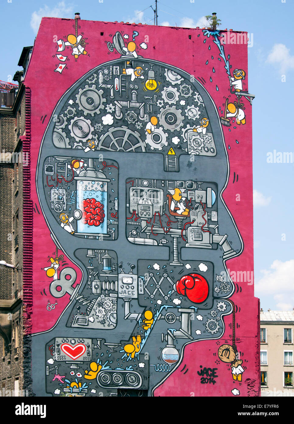 Wandgemälde in Paris des Künstlers Jace, das einen riesigen Kopf mit Zahnrädern, Maschinen und Zeichentrickfiguren darstellt. Stockfoto