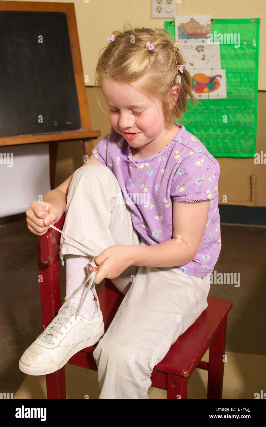4-5 Jahre alten jährigen Mädchen lernen, ihre Schuhe im Klassenzimmer zu binden Krawatten Schnürsenkel Schnürsenkel HERR © Myrleen Pearson Stockfoto