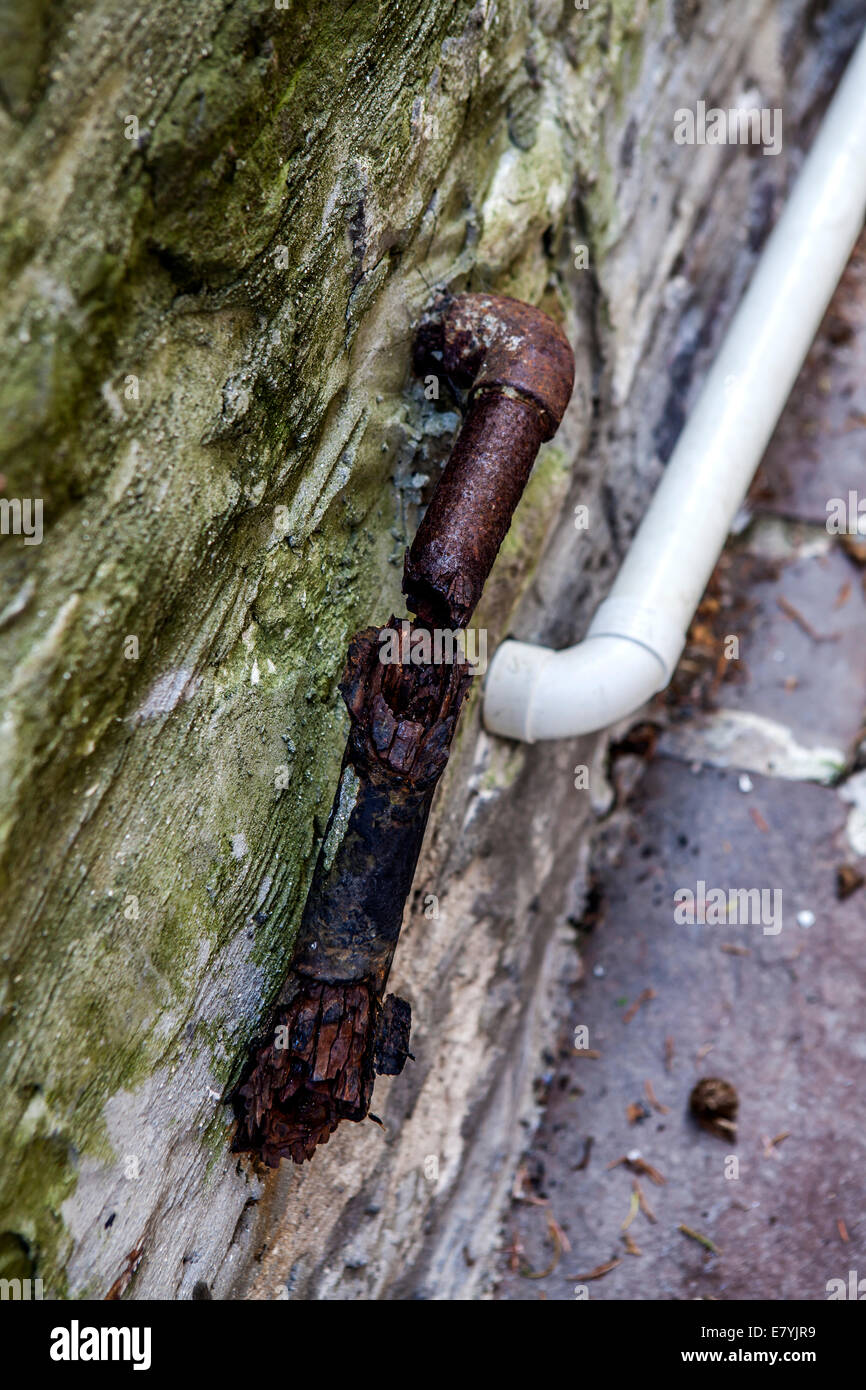 Alte rostige Rohr und neue Rohr installiert auf einem alten Murret Steinen. Stockfoto