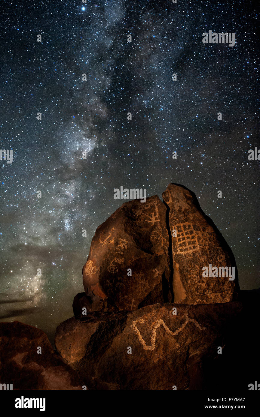 Die Milchstraße erhebt sich hinter einem Felsen bedeckt mit indianischen Petroglyphen, in der Nähe von Gila Bend, Arizona. Stockfoto