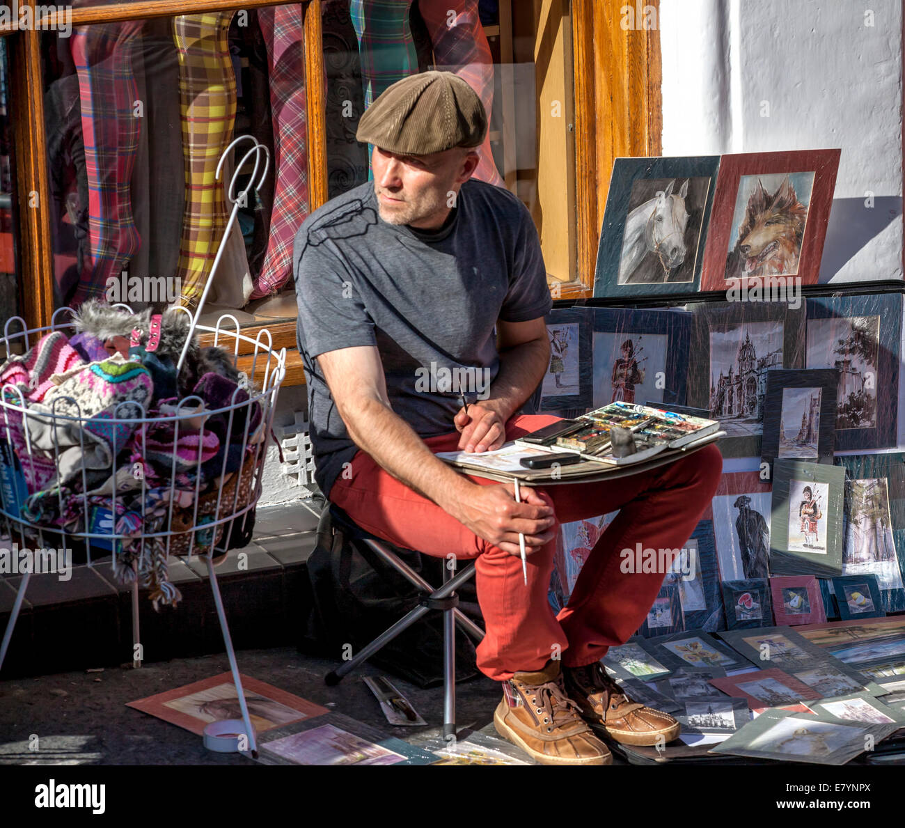 Edinburgh, Scotland, UK - September 2012; Eine Maler-Streetart-Künstler, sitzt vor einem Geschäft, seine Werke zu malen und dann verkaufen Sie Stockfoto