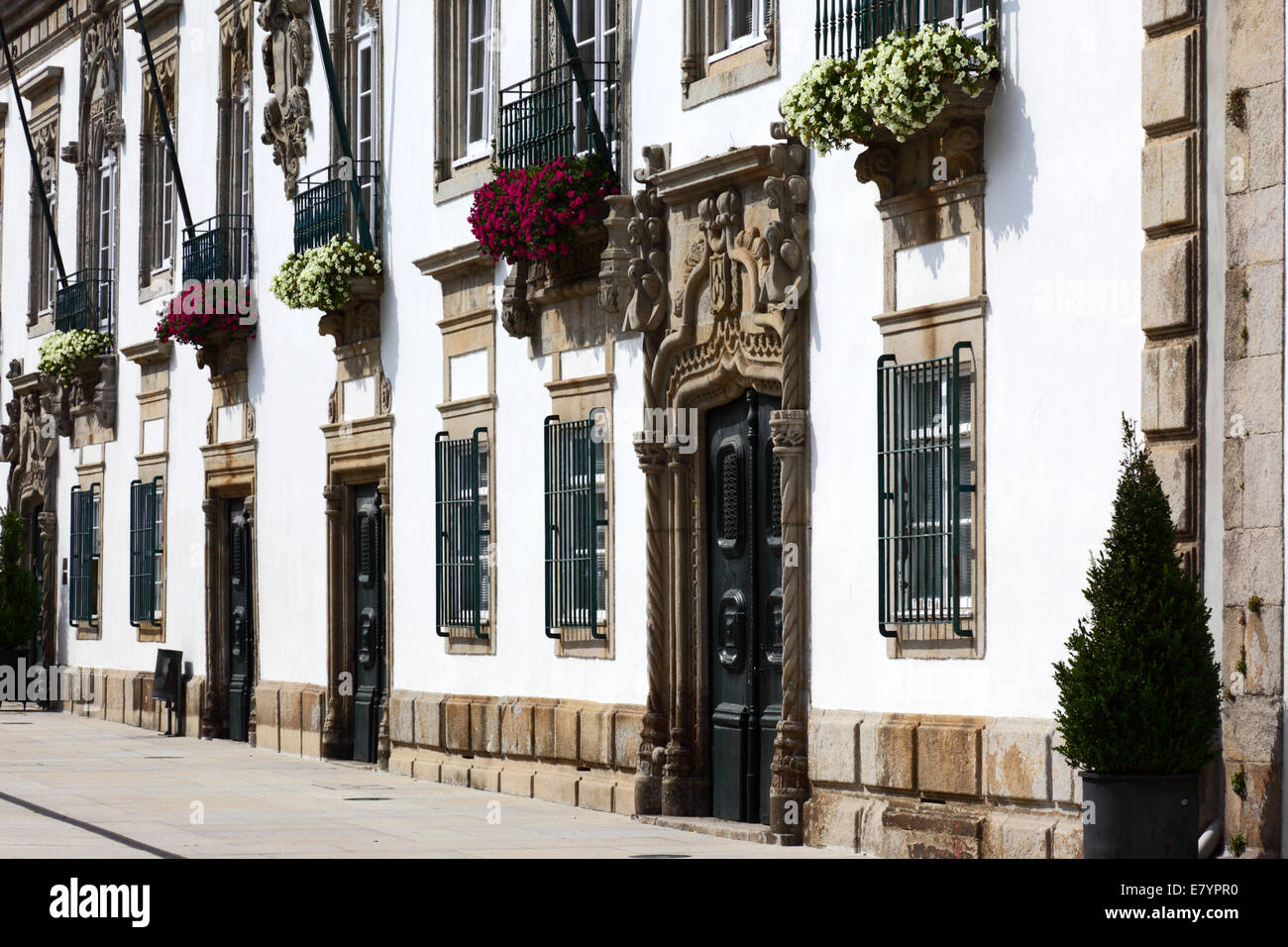 Reich geschnitzte Steintür und Fassade der Villa Casa de Carreira und Geranien in der Fensterbox, Viana do Castelo, Nord-Portugal Stockfoto