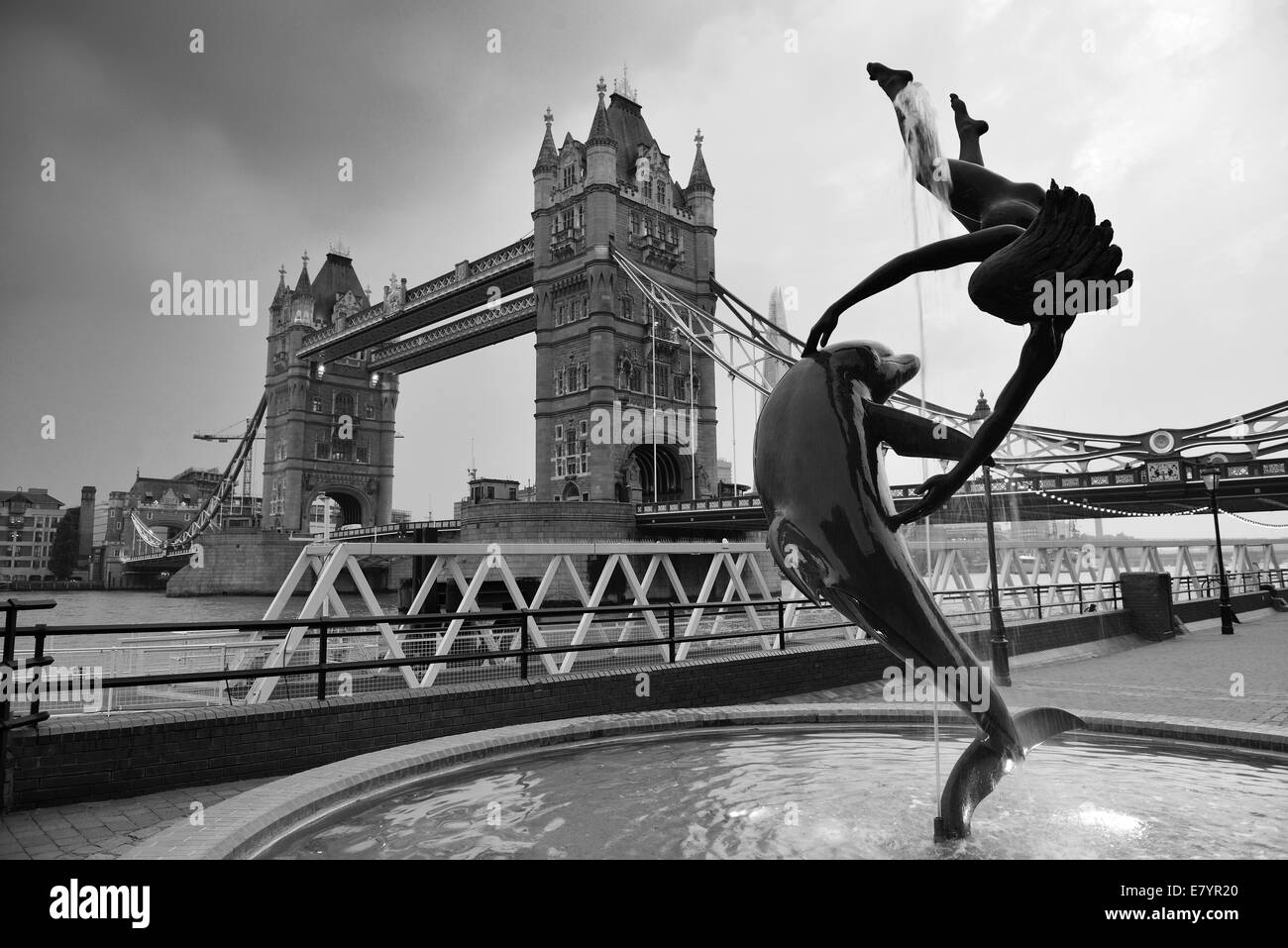 Die Tower Bridge und Statue eines Mädchens mit Delphin in St Katharine Docks in London spielen. Stockfoto