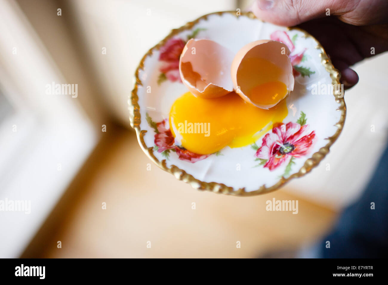 Erhöhten Blick auf gebrochenen Eierschalen und Eigelb auf Platte Stockfoto