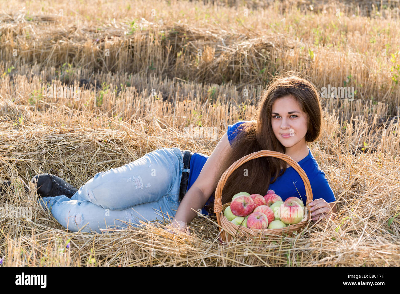 Teengirl mit einem Korb voller Äpfel im Feld Stockfoto