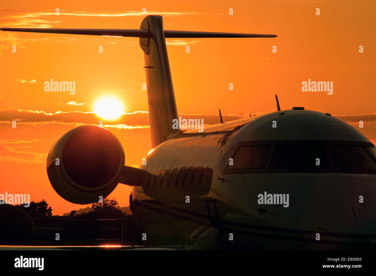 Flughafen-Sonnenuntergang mit goldenen Sonne hinter corporate jet Stockfoto