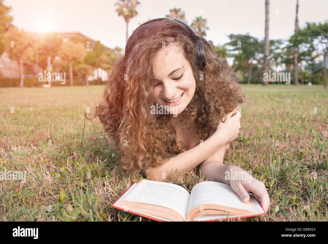 niedliche Mädchen auf Wiese im Park lesen Stockfoto