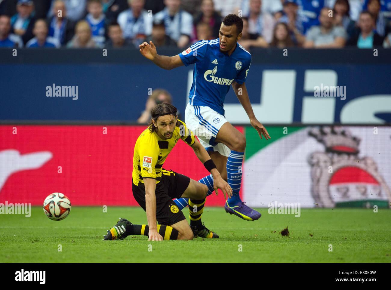 Gelsenkirchen, Deutschland. 27. Sep, 2014. Schalke Eric Maxim Choupo-Moting (R) und der Dortmunder Neven Subotic wetteifern um den Ball in der deutschen Bundesliga-Fußballspiel zwischen FC Schalke 04 und Borussia Dortmund in Veltins Arena in Gelsenkirchen, Deutschland, 27. September 2014. Foto: Bernd Thissen /dpa (Achtung: die DFL schränkt die Nutzung und Veröffentlichung der sequentiellen Bilder über das Internet und andere Online-Medien während des Spiels auf 15 Bilder pro Spiel.) / Dpa/Alamy Live News Stockfoto