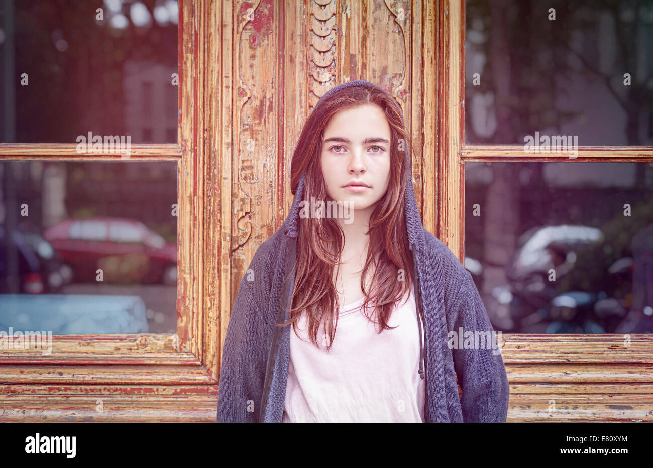 getönten Bild, Porträt von einem Teenager Mädchen vor einer alten Holztür mit Windows. Stockfoto