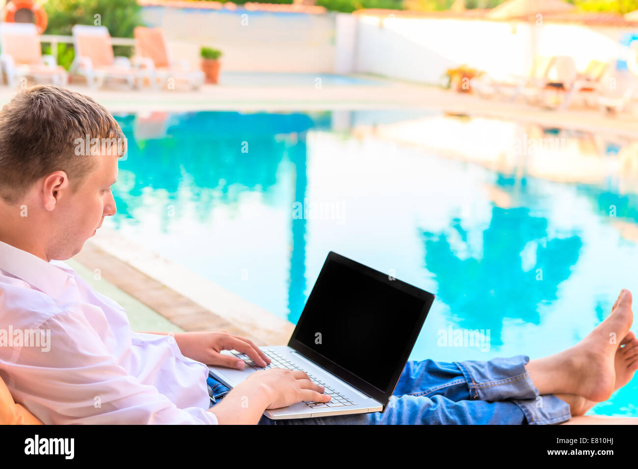 Manager im weißen Hemd auf einem Liegestuhl am Pool Stockfoto