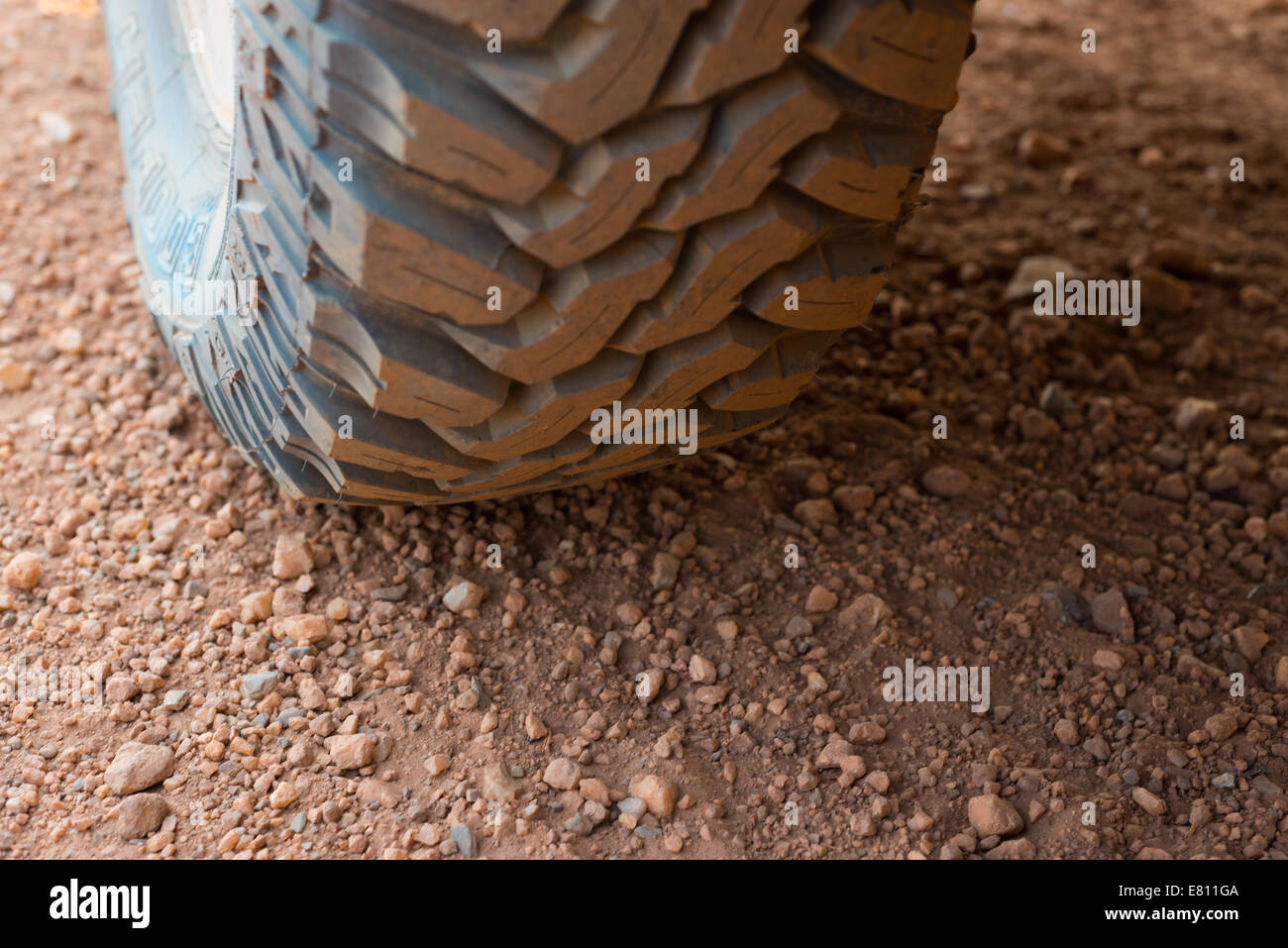 Ein robuste Cooper hergestellt Schlamm Terrain 4 x 4 Reifen hautnah auf dem Schmutz / Schotterstraße. Stockfoto