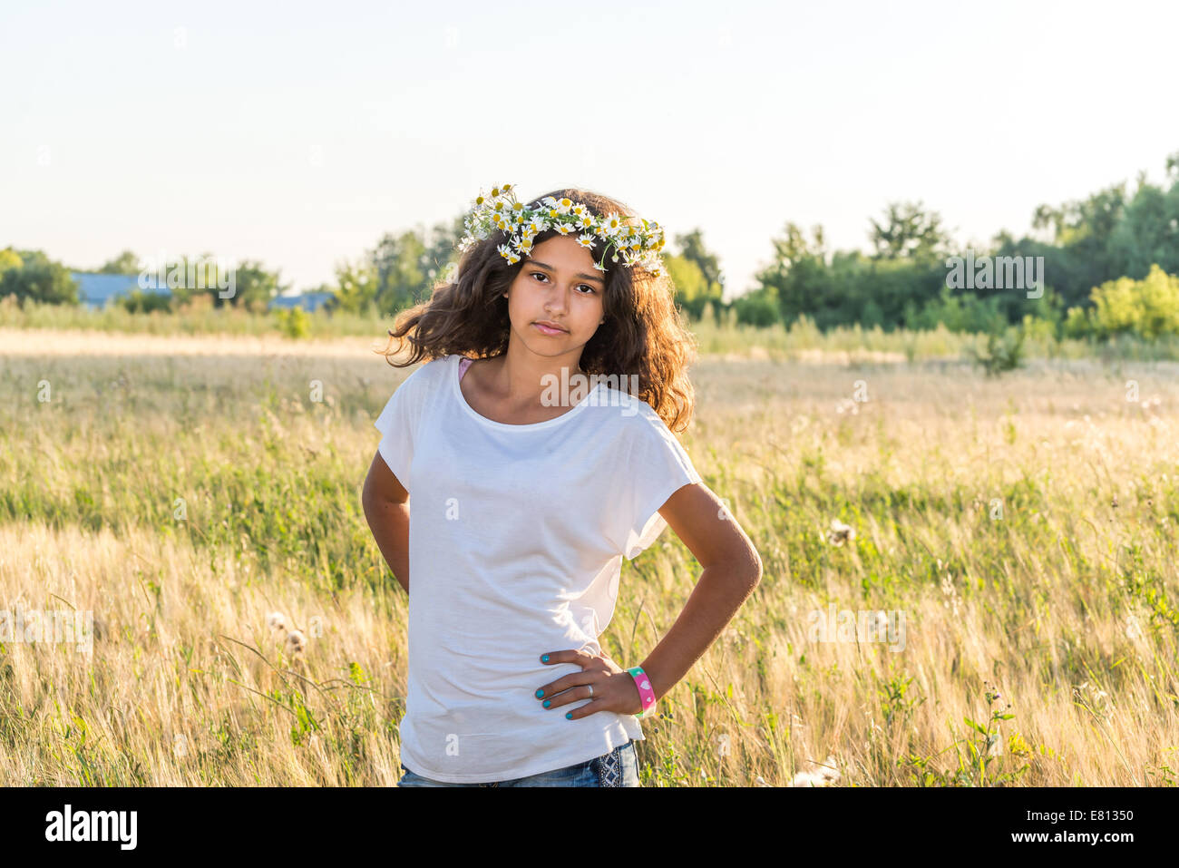 Teengirl mit einem Kranz aus Margeriten in Feld Stockfoto