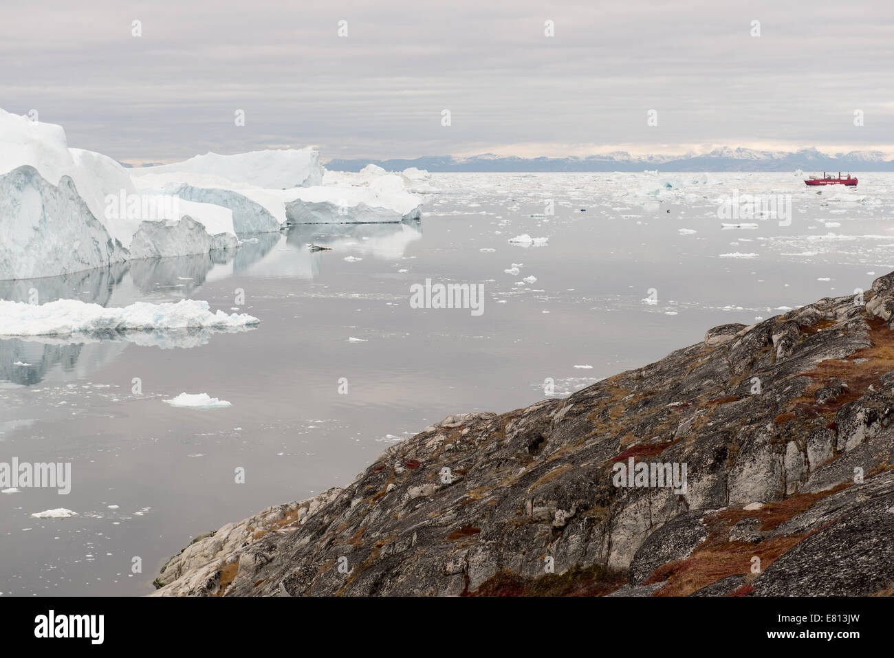 Arktische Landschaft in Grönland um diskoinsel mit Eisbergen, Meer, Berge, cloudscape und Royal Arctic Line Schiff Stockfoto