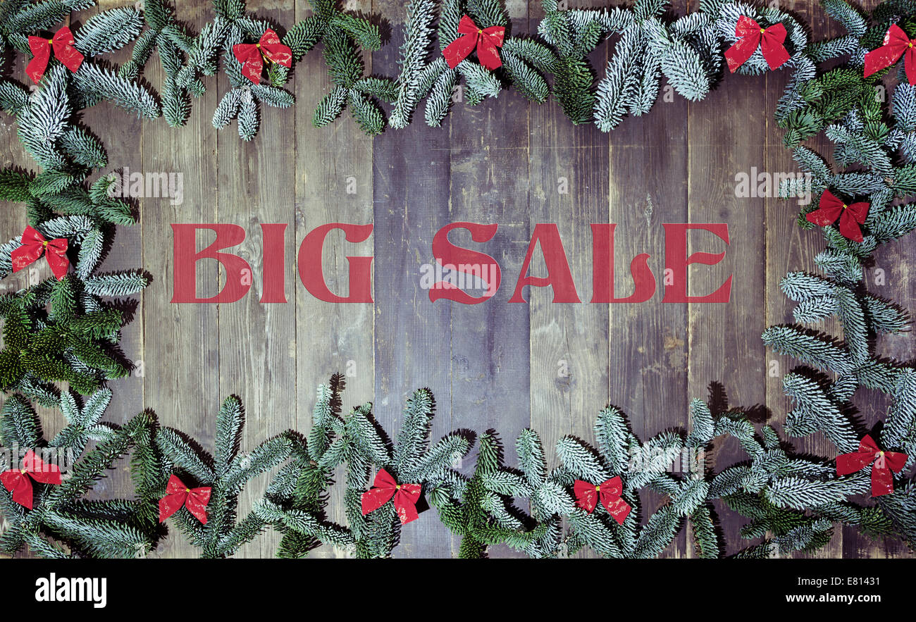 ein alten hölzernen Hintergrund dekoriert mit Tannenzweigen, ein Weihnachten Hintergrund mit Text big Verkauf Stockfoto