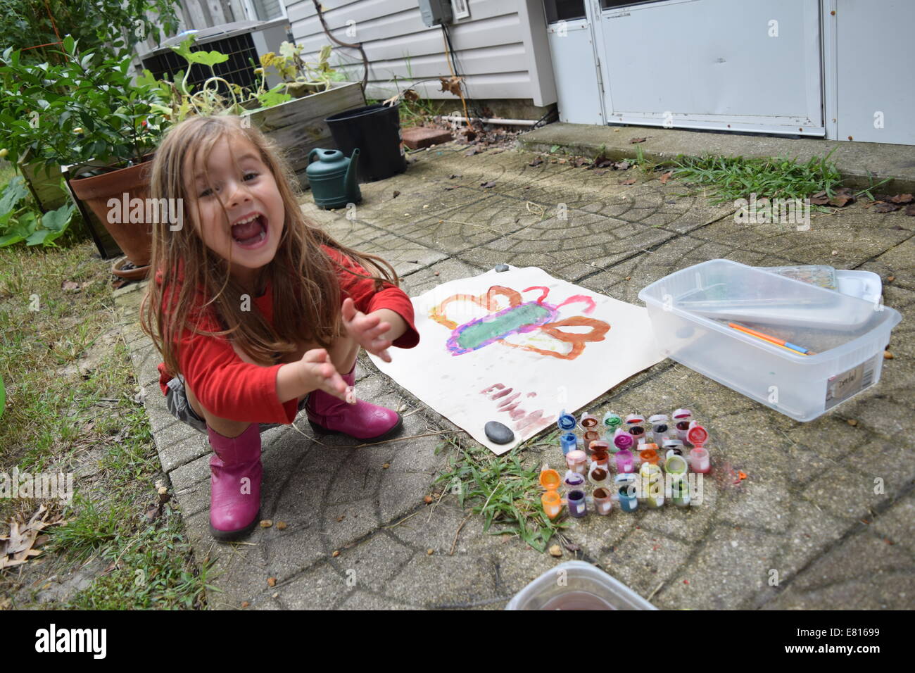 lächelndes Mädchen klatschte neben Aquarell Kunstwerk Schmetterling Stockfoto