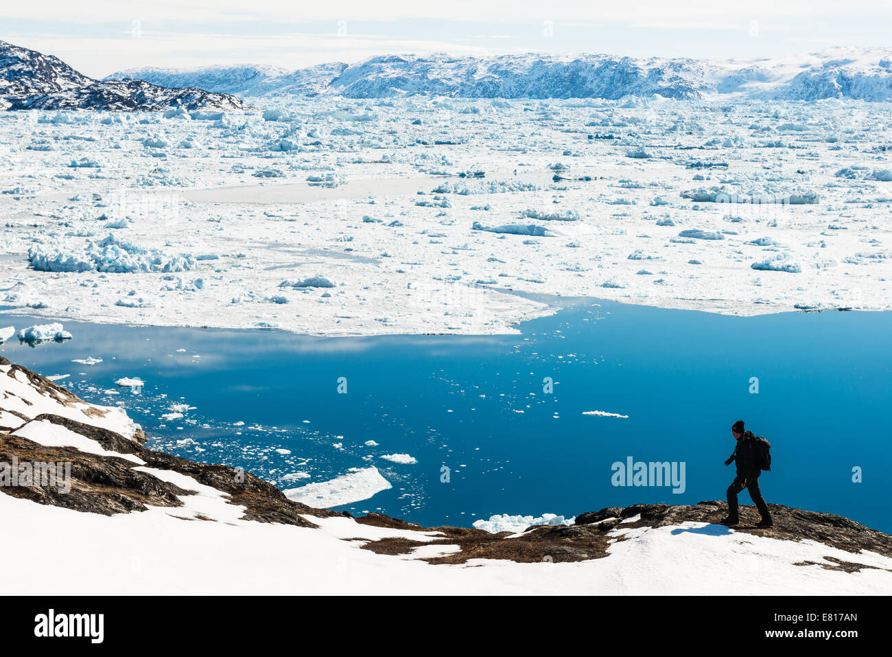 Wanderer-Wanderungen entlang der Küste von verschneiten waters Stockfoto