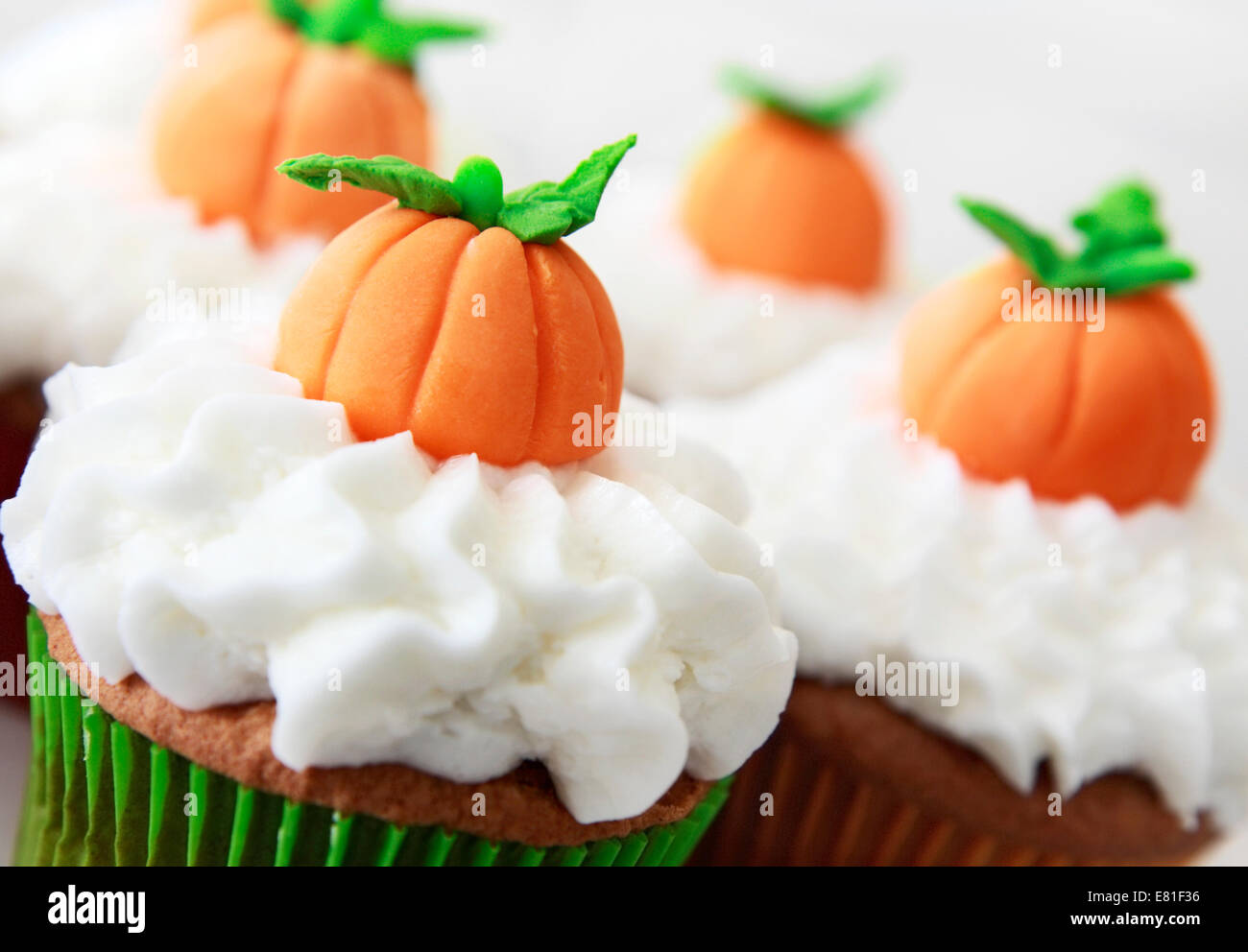 Kürbis Gewürz-Cupcakes mit Vanille Zuckerguss dekoriert für Halloween und Thanksgiving Stockfoto