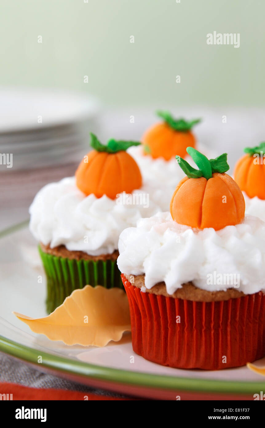 Kürbis Gewürz-Cupcakes mit Vanille Zuckerguss dekoriert für Halloween und Thanksgiving Stockfoto
