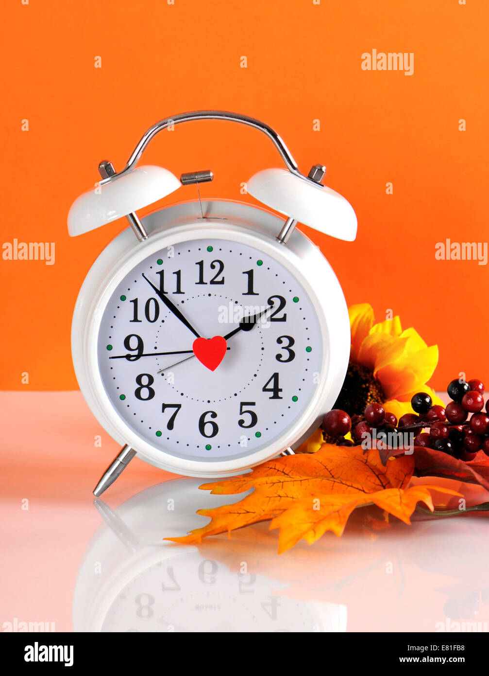 Sommerzeit endet im Herbst Herbst mit Uhr Konzept auf orangem Hintergrund. Stockfoto