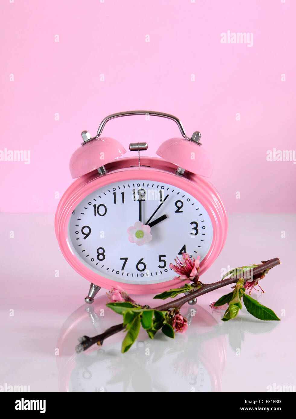 Sommerzeit beginnt Zeit Uhr Konzept für beginnen im Frühjahr vor einem rosa Hintergrund. Stockfoto