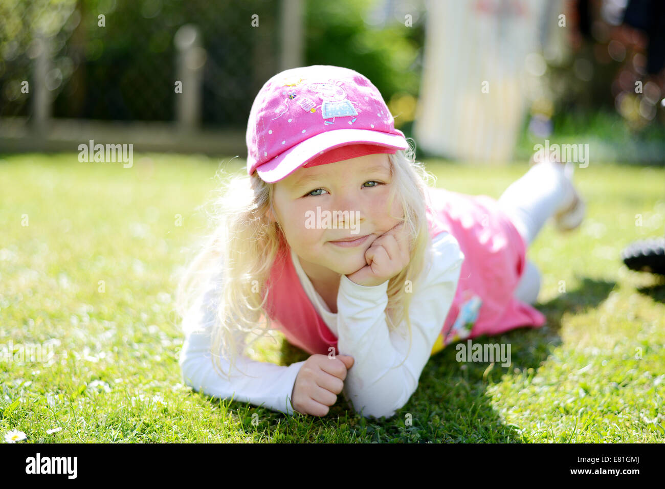 Fünf Jahre altes Mädchen posiert in den Garten schauen und Lächeln in die Kamera Stockfoto