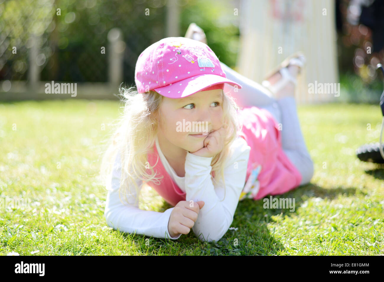 Fünf Jahre altes Mädchen posiert in den Garten mit Blick weg von der Kamera Stockfoto