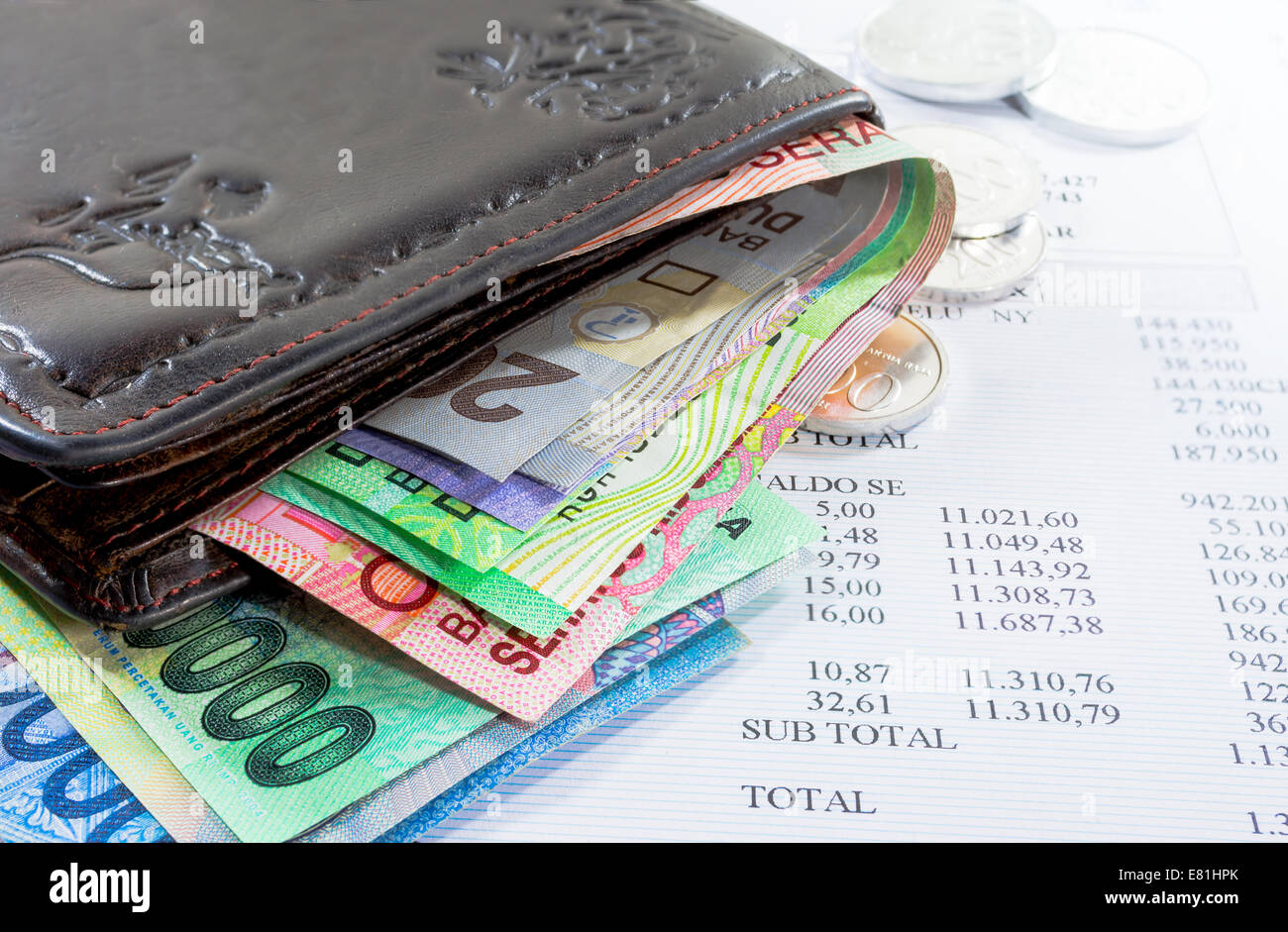 Brieftasche und Geld in verschiedene Banknoten und Münzen mit Kreditkartenabrechnung als Hintergrund Stockfoto
